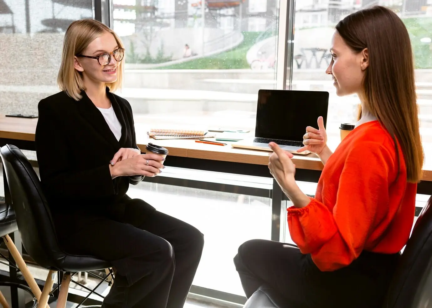 Businesswomen communicate at work using sign language.